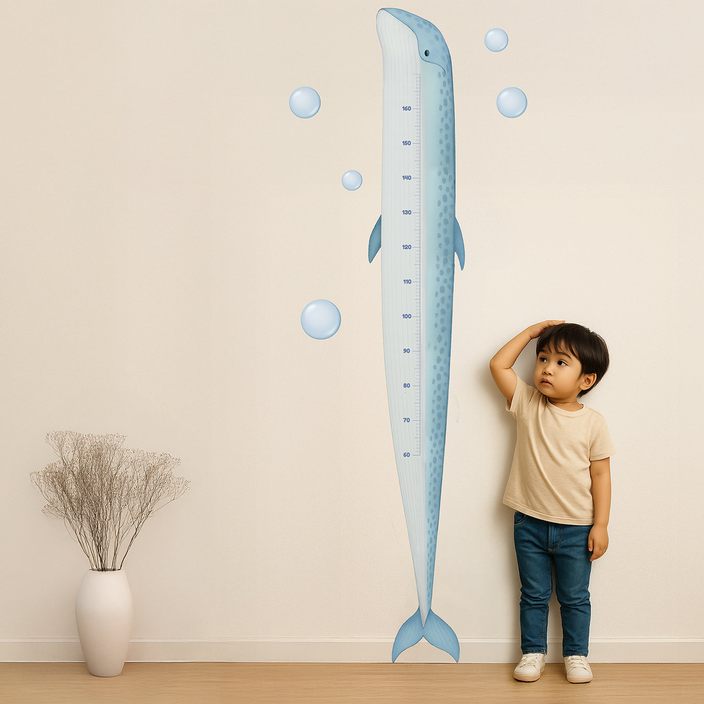 Ocean-themed whale height chart wall decal with bubble accents and milestone fish markers, shown in a modern nursery with a toddler measuring growth printed on Phototex